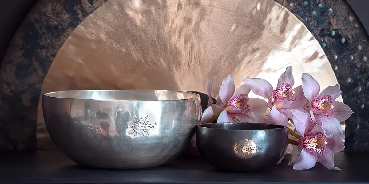 A Healingbowl silver massage bowl and a small bowl, both with the hand-punched mark