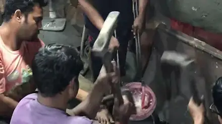 Craftsmen forging a glowing bronze disc by hand