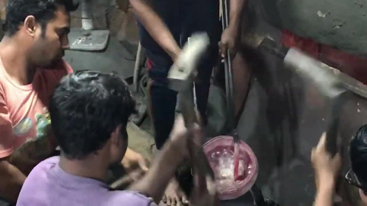 Craftsmen forging a glowing bronze disc by hand